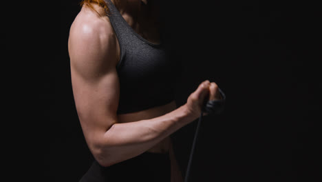 Close-Up-Studio-Shot-Of-Mature-Woman-Wearing-Gym-Fitness-Clothing-Exercising-With-Resistance-Band